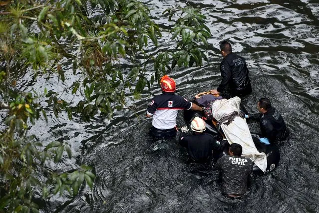 Rescuers remove a body from the crash site of a bus which ran off a highway bridge in Atoyac in Veracruz state, Mexico, January 10, 2016. Sixteen people died and 10 people were injured in a bus accident in the Gulf coast state of Veracruz, the state government said on Sunday. (Photo by Yahir Ceballos/Reuters)