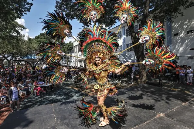 A candidate in a Mardi Gras themed costume contest faces village residents during a parade to mark the Catholic feast day of San Roque (Saint Roch) in Manila, Philippines, 16 August 2023. As churches provide solemn places of worship on feast days, Catholics also celebrate and honor their patron saints by holding colorful parades to spread cheer and strengthen communities bonded in faith. (Photo by Rolex Dela Pena/EPA)