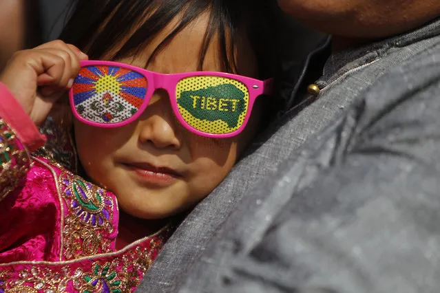 A Tibetan child wears glasses decorated with the Tibetan flag during celebrations to mark their New Year, or Losar, inside the Tibetan Refugee Camp in Lalitpur, Nepal, Thursday, February 19, 2015. (Photo by Niranjan Shrestha/AP Photo)