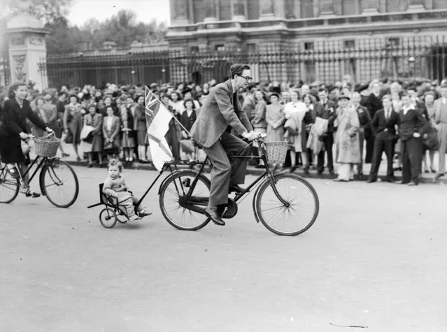 Passing the crowds outside Buckingham Palace on VE Day, a father takes his child on a tour of London's West End in unorthodox style, 8th May 1945. (Photo by Reg Speller/Fox Photos/Getty Images)