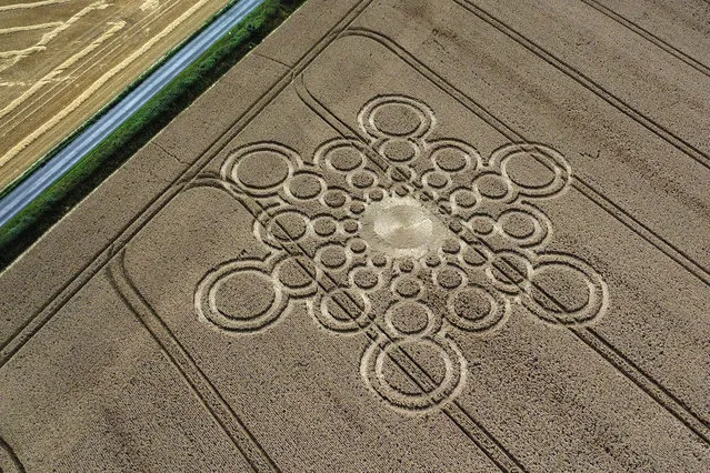 An aerial view of a geometric crop circle, measuring approximately 100 metres, in a field of wheat in Hampshire on July 29, 2023 near Winchester, England. The mysterious crop formations, that appear overnight throughout the Wiltshire and Hampshire countryside, gained popularity in the 1980's when they began to attract media attention. Designs gradually became increasingly more complex, and geometric crop circles have evolved into an international phenomenon, with hundreds seen around the world. Although many crop circles have been proven to be caused by intentional human action, and are considered a form of folk-art, there are many who choose to believe they are created by still unexplained paranormal or extraterrestrial activity. (Photo by Jim Dyson/Getty Images)