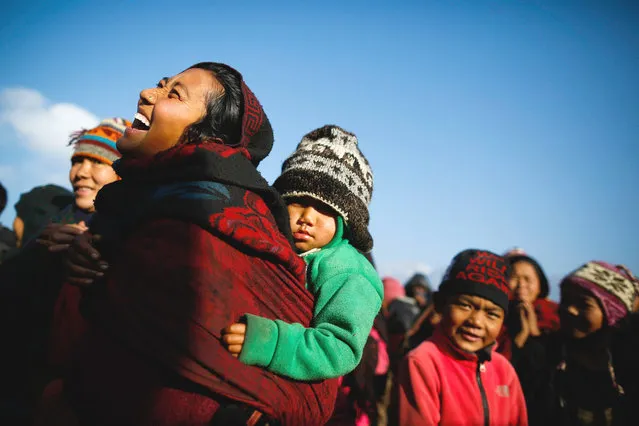 A mother who was affected by earthquake reacts after receiving free blanket at Lapark, in Gorkha district, Nepal, 19 January 2016. Lapark is one of the epicenter villages of Gorkha district, where more than 600 hundreds houses were destroyed during earthquake on 25 April 2015. Hundreds of earthquake victims living in shelter of highland altitude have been facing harsh winterization season after snowfall in Lapark. (Photo by Narendra Shrestha/EPA)