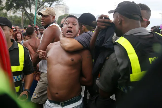 A man is detained for suspected robbery during the Gay Pride Parade at the Copacabana beach in Rio de Janeiro, Brazil, December 11, 2016. (Photo by Pilar Olivares/Reuters)