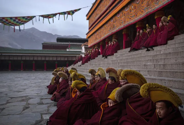 Tibetan Buddhist Monks of the Gelug, or Yellow Hat order, sit before taking part in morning prayers during Monlam or the Great Prayer rituals on March 3, 2015 at the Labrang Monastery, Xiahe County, Amdo, Tibetan Autonomous Prefecture, Gansu Province, China. (Photo by Kevin Frayer/Getty Images)