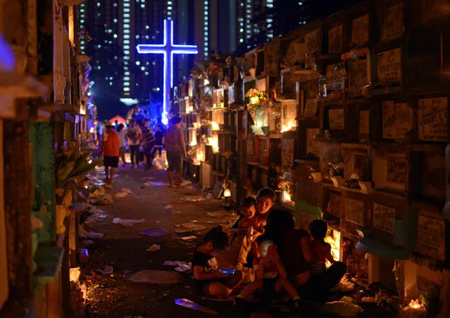 Filipino families visit the graves of their departed loved ones during All Saints Day in a public cemetery in Makati City, Metro Manila, Philippines on October 31, 2018. (Photo by Eloisa Lopez/Reuters)