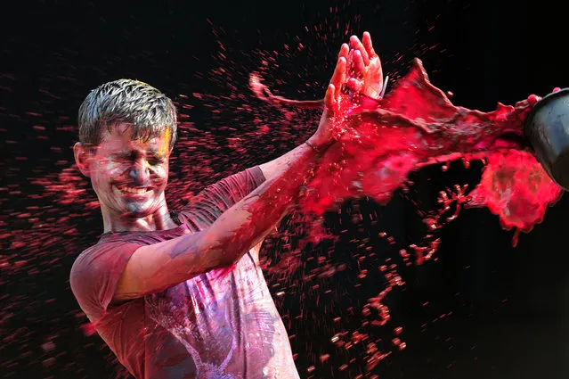 An Indian  man get his face smeared with colors as he takes part in Holi celebrations in Chennai on March 24, 2016. The Hindu festival of Holi, or the “Festival of Colours” heralds the arrival of spring and the end of winter. (Photo by Arun Sankar/AFP Photo)