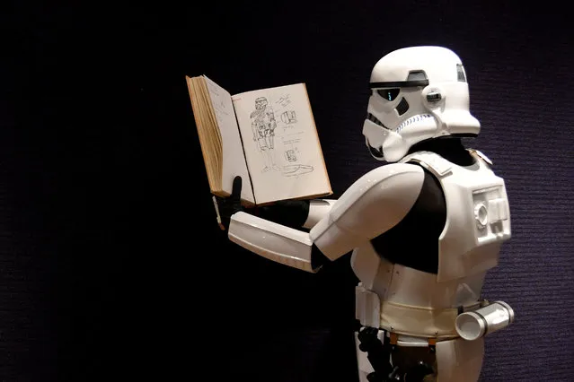 A man wearing a storm trooper costume holds a sketchbook belonging to costume designer John Mollo, and showing illustrations for Star Wars costumes, during a photo-call ahead of an auction at Bonhams in central London, Britain December 6, 2018. (Photo by Toby Melville/Reuters)