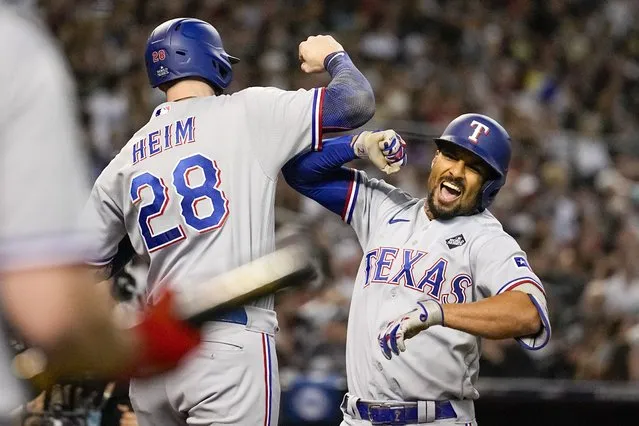 Texas Rangers' Marcus Semien, right, celebrates his three-run home run with Jonah Heim during the third inning in Game 4 of the baseball World Series against the Arizona Diamondbacks Tuesday, October 31, 2023, in Phoenix. (Photo by Brynn Anderson/AP Photo)