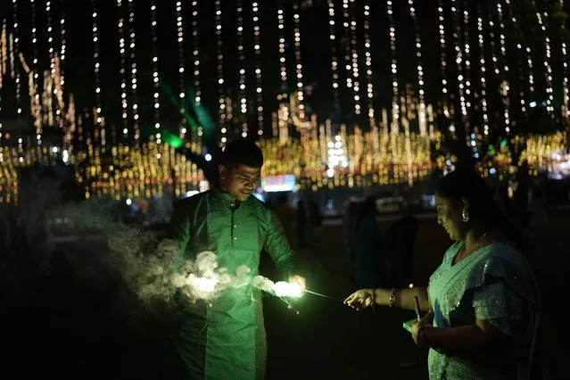 People light fire crackers during festival of lights Diwali in Mumbai, India, Sunday, November 12, 2023. (Photo by Rajanish Kakade/AP Photo)