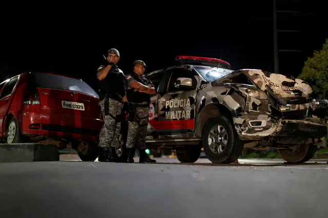 Riot police officers are seen next to their damaged car after chasing a stolen car in Manaus, Brazil, January 6, 2017. Police erected roadblocks and increased patrols around Manaus to hunt down more than 100 inmates who escaped from a prison in Manaus during a riot. According to local media, police reported more than 12 murders have occurred in Manaus for the past 24 hours. (Photo by Ueslei Marcelino/Reuters)