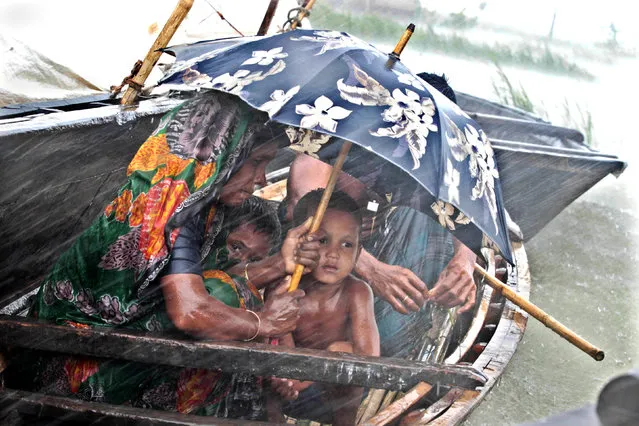 “Flood Effected Mother and Children”. A woman sits with her child in a boat during heavy rains at a flooded village in Kurigram, a northern district of Bangladesh. Photo location: Kurigram, Bangladesh. (Photo and caption by Andrew Biraj/National Geographic Photo Contest)