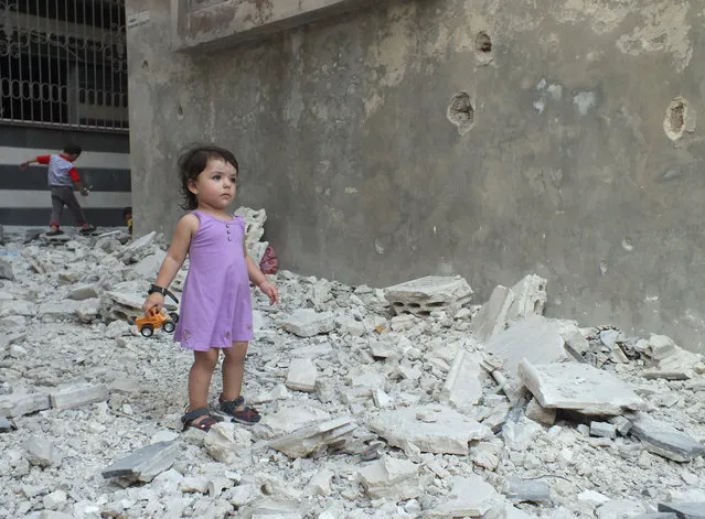 A girl stands on debris next to a damaged building at a besieged area of Homs, August 2, 2012. (Photo by Yazen Homsy/Reuters)