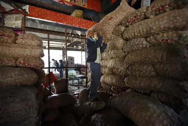 A man lifts a sack of onions inside a vegetable market in Kathmandu February 9, 2015. (Photo by Navesh Chitrakar/Reuters)