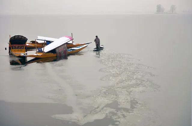 A Kashmiri boatman uses his oar to break the ice layer of the frozen Dal Lake after a heavy snowfall in Srinagar on January 7, 2017. Indian-administered Kashmir has been cut off from the rest of the country for the second day after heavy snowfall closing the 294km Jammu-Srinagar national highway, the only road link between Kashmir and rest of the country. (Photo by Tauseef Mustafa/AFP Photo)