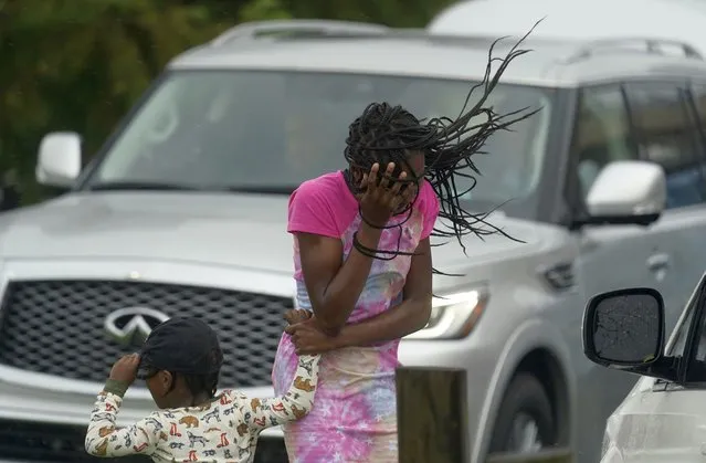 A young girl blocks her face from the wind and rain produced by Hurricane Ida, Sunday, August 29, 2021, in New Orleans, La. (Photo by Eric Gay/AP Photo)