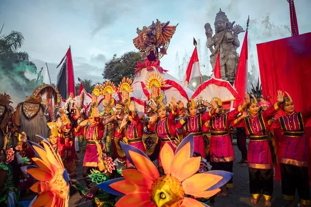 Balinese dancers perform as they take part in a cultural parade, during a new year's eve celebration at a main road in Denpasar, Bali, Indonesia on December 31, 2023. (Photo by Made Nagi/EPA/EFE)