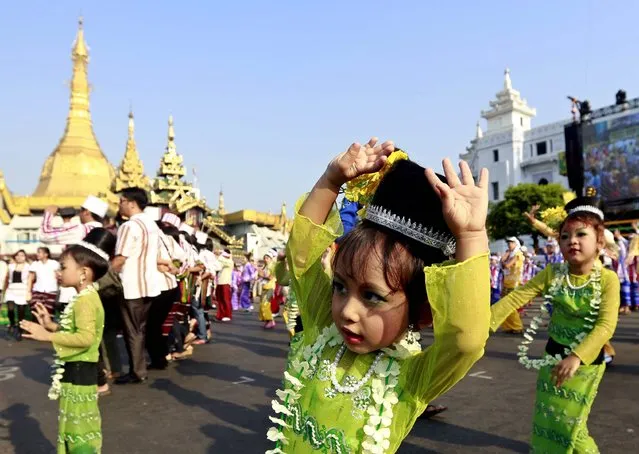 Young girls perform during the opening ceremony of the Yangon Mayor water festival in Yangon, Myanmar, 13 April 2015. The annual water festival is celebrated with large groups of people congregating to celebrate by splashing water and throwing powder at each others faces as a symbolic sign of cleansing and washing away the sins from the old year to mark the traditional New Year in countries such as Myanmar, Thailand, Laos and Cambodia. (Photo by Nyein Chan Naing/EPA)