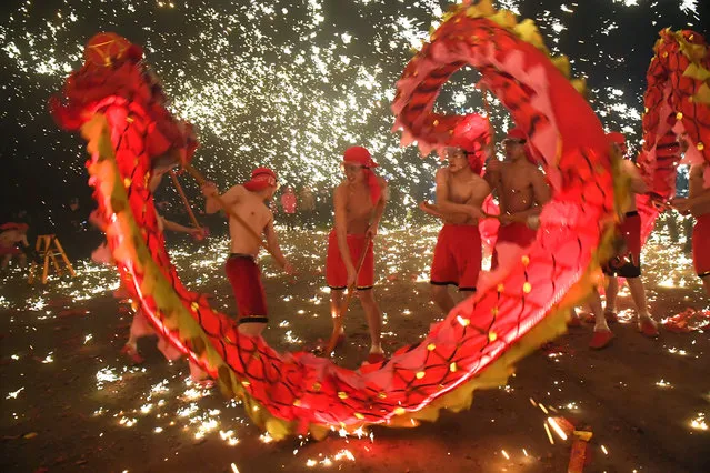 Folk artists perform a dragon dance under a shower of molten iron sparks during an event to celebrate the upcoming Chinese Lantern Festival in Anshan, Guizhou province, China February 18, 2019. (Photo by Reuters/China Stringer Network)