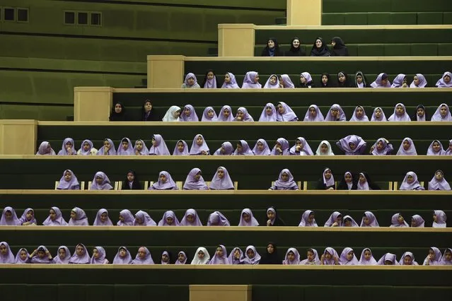 Iranian schoolgirls follow debates of lawmakers in an open session of the outgoing parliament in Tehran, Iran, Tuesday, March 1, 2016. A coalition of moderates and reformists gained bigger ground in the new parliament after Friday elections, the biggest presence of the camp over the past decade. The new parliament will take office in late May. (Photo by Vahid Salemi/AP Photo)