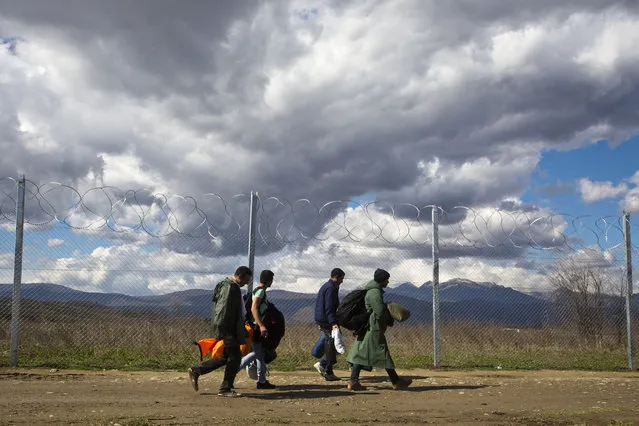 Migrants make their way to the registration and transit camp after entering Macedonia from Greece near the southern Macedonian town of Gevgelija, Friday, March 4, 2016. Thousands of refugees and migrants continue to wait on the border between Greece and Macedonia on Thursday morning. At the moment, some 30,000 refugees and other migrants are stranded in Greece, with 10,000 at the Idomeni border crossing to Macedonia. (Photo by Visar Kryeziu/AP Photo)