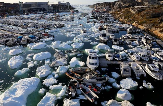 Ice floats around boats in the port on September 02, 2021 in Ilulissat, Greenland. Greenland in 2021 is experiencing one of its biggest ice-melt years in recorded history. Scientists studying the Greenland Ice Sheet observed rainfall on the highest point in Greenland for the first time ever this August. Researchers from Denmark estimated that in July of this year enough ice melted on the Greenland Ice Sheet to cover the entire state of Florida with two inches of water. The observations come on the heels of the recent United Nations report on global warming which stated that accelerating climate change is driving an increase in extreme weather events. (Photo by Mario Tama/Getty Images)