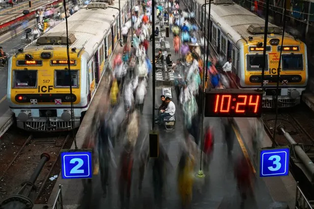 Commuters walk along platforms at the Churchgate railway station in Mumbai on January 31, 2024. (Photo by Punit Paranjpe/AFP Photo)