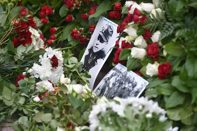 An old photograph sticks between flowers laid down at the Monument of Freedom in Riga, Latvia on March 16, 2016, where veterans of the Latvian Legion, a force that was commanded by the German Nazi Waffen SS during WWII, and their sympathizers commemorated a key 1944 battle in their ultimately failed attempt to stem a Soviet advance. Jewish groups, Moscow and some in Latvia's ethnic-Russian community see the parade as glorifying Nazism because the Legion, founded in 1943, was commanded by Germany's Waffen SS, the armed wing of the Nazi party's Schutzstaffel SS (Protective Squadron). (Photo by Ilmars Znotins/AFP Photo)
