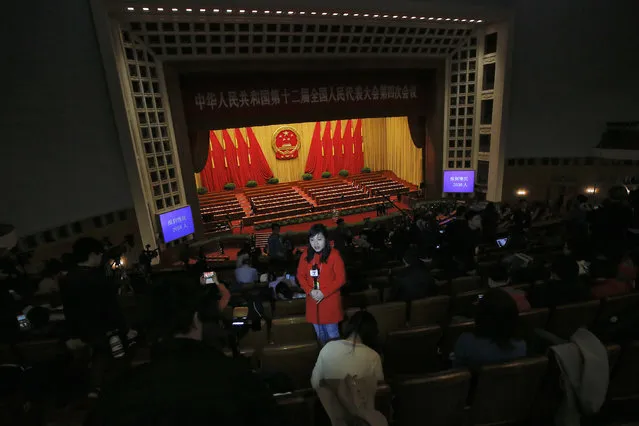 A reporter stands inside the Great Hall of the People during the closing ceremony of China's National People's Congress (NPC) in Beijing, China, March 16, 2016. (Photo by Kim Kyung-hoon/Reuters)