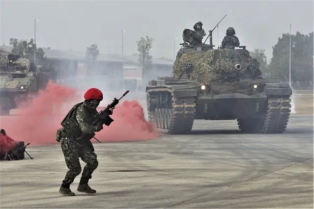 A solider reacts as a tank approaches during a preparedness enhancement drill simulating the defense against Beijing's military intrusions, ahead of the Lunar New Year in Kaohsiung City, Taiwan on Wednesday, January 11, 2023. China renewed its threats Wednesday to attack Taiwan and warned that foreign politicians who interact with the self-governing island are “playing with fire”. (Photo by Daniel Ceng/AP Photo)