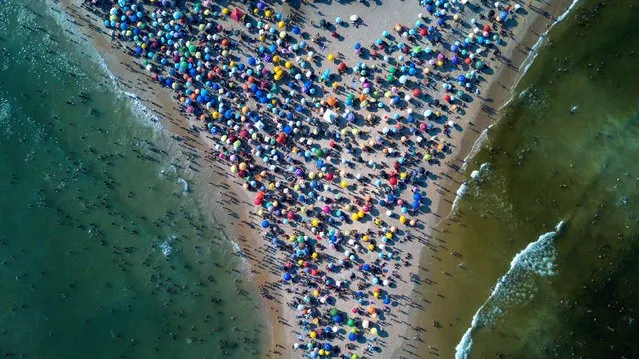 People gather at Recreio dos Bandeirantes beach amid a heat wave in Rio de Janeiro on Sunday, March 17, 2024. (Photo by Terico Teixeira/AFP Photo)