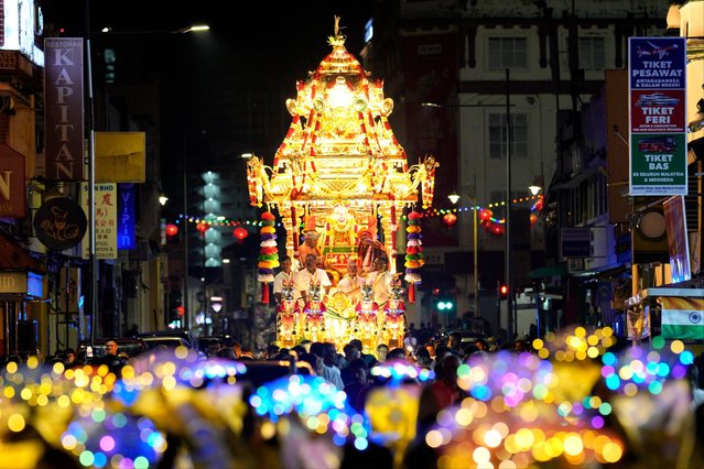 The gold chariot bearing the idol of Hindu god Lord Murugan leaves a temple to mark the start of Thaipusam, an annual festival representing the struggle between good and evil, on Penang Island, Wednesday, January 24, 2024. Thousands of people attended the annual procession celebrated by devotees in honor of the Hindu god to express their gratitude, fulfill vows, and perform penance. (Photo by Vincent Thian/AP Photo)