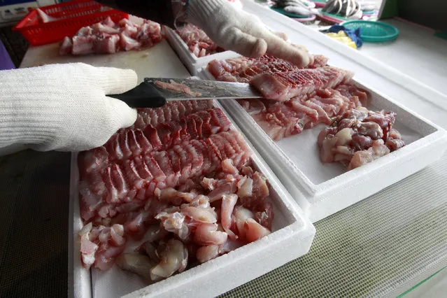 In this February 19, 2014 photo, a skate seller puts slices of skate into styrofoam boxes for shipment to customers around South Korea at a fish market in Mokpo, a port city on the southwestern tip of the Korean Peninsula. The aroma of one of southwestern South Korea's most popular delicacies regularly gets compared to rotting garbage and filthy bathrooms. (Photo by Ahn Young-joon/AP Photo)