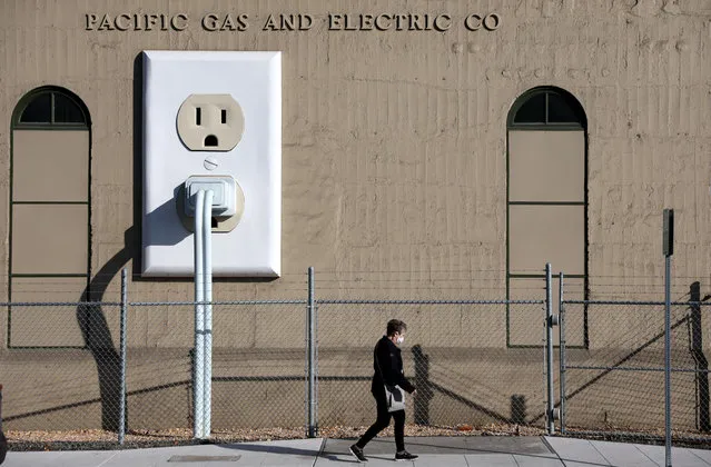 A pedestrian walks by a Pacific Gas & Electric (PG&E) electrical substation on January 26, 2022 in Petaluma, California. The Department of Homeland Security (DHS) is warning that domestic extremists have been developing specific plans to target electrical infrastructure in the United States. (Photo by Justin Sullivan/Getty Images)