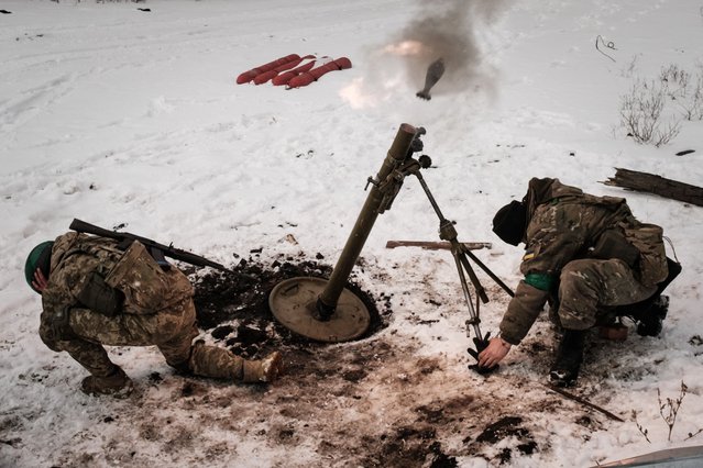 Ukrainian serviceman of the State Border Guard Service fire a mortar toward the Russian position in Bakhmut on February 16, 2023, as the head of Russia's mercenary outfit Wagner said it could take months to capture the embattled Ukraine city and slammed Moscow's “monstrous bureaucracy” for slowing military gains. Russia has been trying to encircle the battered industrial city and wrest it ahead of February 24, the first anniversary of what it terms its "special military operation" in Ukraine. (Photo by Yasuyoshi Chiba/AFP Photo)