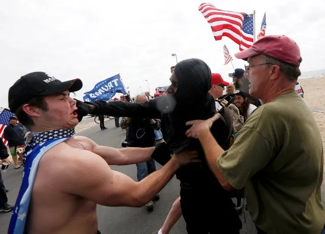 A pro-Trump rally participant is punched in the face by an anti-Trump protester  as the two sides clash during a Pro-Trump rally in Huntington Beach, California, U.S., March 25, 2017. (Photo by Patrick T. Fallon/Reuters)