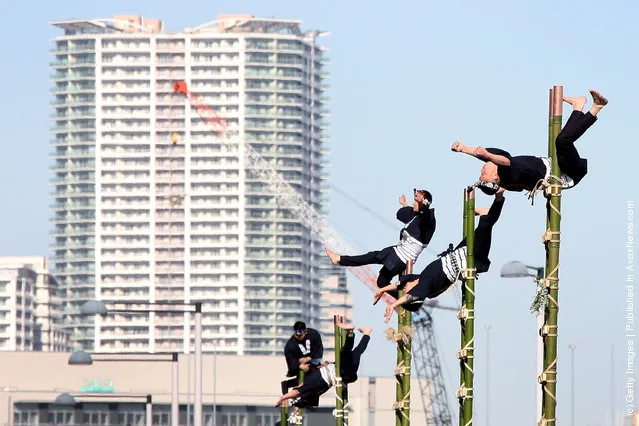 Members of the Edo Firemanship Preservation Association balance on top of bamboo ladders as they perform ladder stunts during the New Year's fire review conducted by the Tokyo Fire Department