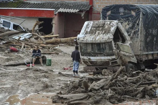 People stare at damages caused by mudslides following heavy rains in Mocoa, Putumayo department, southern Colombia on April 2, 2017. The death toll from a devastating landslide in the Colombian town of Mocoa stood at around 200 on Sunday as rescuers clawed through piles of muck and debris in search of survivors. (Photo by Luis Robayo/AFP Photo)