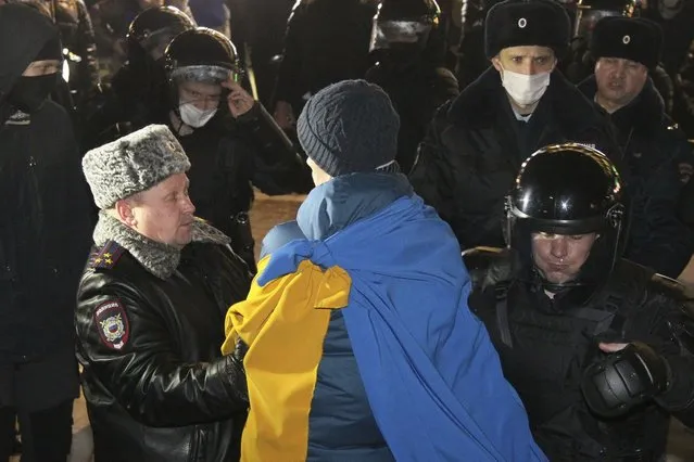 Police officers detain a protester in Nizhny Novgorod, Russia, Thursday, February 24, 2022. Hundreds of people gathered in the center of Moscow, St. Petersburg, Nizhny Novgorod and other Russian cities on Thursday, protesting against Russia's attack on Ukraine. Many of the demonstrators were detained. Similar protests took place in other Russian cities, and activists were also arrested. (Photo by Dmitri Lovetsky/AP Photo)