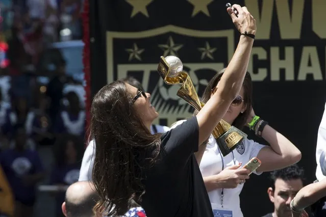 Carli Lloyd of the U.S. women's soccer team takes a selfie with the World Cup Trophy while riding in a float during the ticker tape parade up Broadway in lower Manhattan to celebrate the team's World Cup final win over Japan in New York, July 10, 2015. (Photo by Mike Segar/Reuters)
