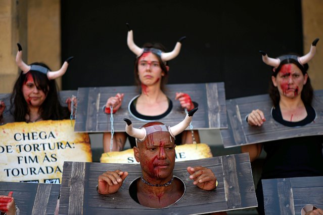 People take part in a protest against animal cruelty before the start of the San Fermin festival at Plaza del Ayuntamiento square as banner, reads “Stop the torture; End Bullfighting”, in Pamplona, northern Spain, Friday, July 5, 2024. On July 6th, the San Fermin festival will begin and last for nine days where thousands of people will take part in the famous running of the bulls through the old streets of the city. (Photo by Alvaro Barrientos/AP Photo)