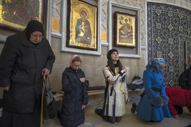Woman pray inside the “Transfiguration of Jesus” Orthodox Cathedral, in Kyiv, Ukraine, Sunday, March 20, 2022. (Photo by Rodrigo Abd/AP Photo)