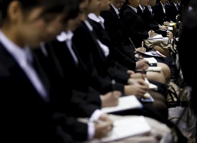 Female job seekers take notes as they attend an orientation session at a company booth during a job fair held for fresh graduates in Tokyo, Japan, March 20, 2016. (Photo by Yuya Shino/Reuters)