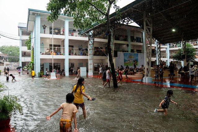 Children play amid flooding at a school temporarily converted into an evacuation center following heavy rains brought by Typhoon Gaemi, in Marikina City, Metro Manila, Philippines, on July 24, 2024. (Photo by Lisa Marie David/Reuters)