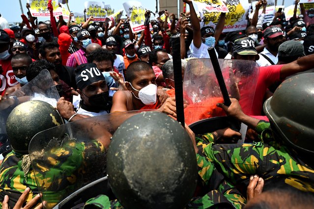 Police Special Task Force officers try to stop demonstrators during a protest against the rising living costs, outside President Gotabaya Rajapaksa's seafront office in Colombo on March 18, 2022. (Photo by Ishara S. Kodikara/AFP Photo)