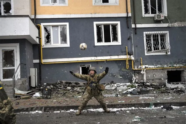 A Ukranian soldier eyes a soccer ball during a pick-up game in Irpin, on the outskirts of Kyiv, Ukraine, Saturday, April 2, 2022. (Photo by Rodrigo Abd/AP Photo)