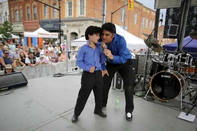 Elvis Presley tribute artist Norm Ackland, Jr of Windsor, Ontario performs with his son Jax on a street stage at the four-day Collingwood Elvis Festival in Collingwood, Ontario July 25, 2015. Ackland Jr's father was Canada's first Elvis tribute artist, starting his career in 1968. (Photo by Chris Helgren/Reuters)