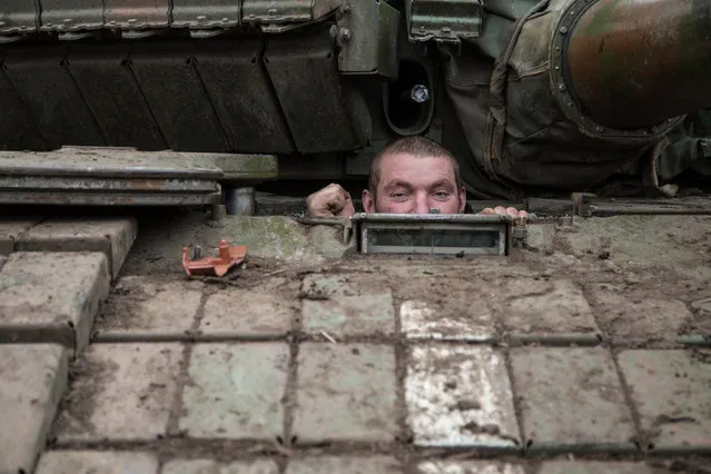 A Ukrainian serviceman looks out from a tank at a base near the village of Peski, Donetsk region, on February 16, 2015. Ukraine's army is not planning to pull its heavy weapons back from the frontline late Monday, as it is meant to do under a nascent truce, because of continued attacks by pro-Russian rebels, a military spokesman told AFP. (Photo by Oleksandr Ratushniak/AFP Photo)