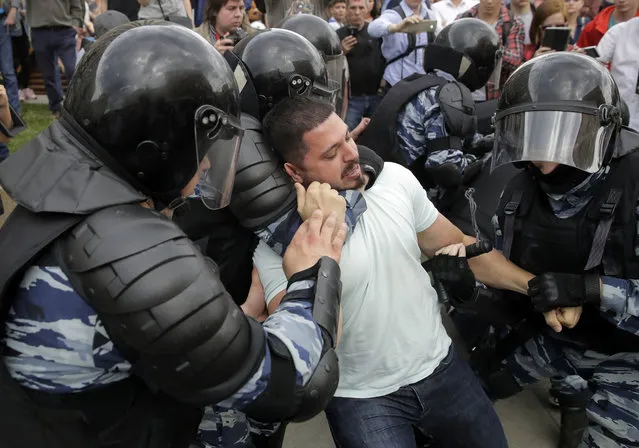 Police detain a protester during a demonstration in downtown Moscow, Russia, Monday, June 12, 2017. (Photo by Pavel Golovkin/AP Photo)