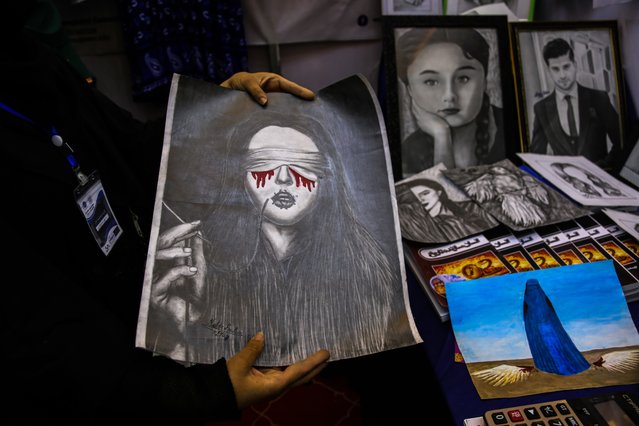 An Afghan woman shows a painting at the 'Afghanistan's Economic Development and Success' in Kabul, Afghanistan, 27 August 2024. A four-day exhibition titled “Afghanistan's Economic Development and Success” has opened in Kabul, showcasing products from industrialists in 310 booths, with 150 dedicated to handicrafts. The Taliban Ministry of Industry and Trade said it emphasizes the importance of such exhibitions for promoting domestic products to enhance economic growth. The Chamber of Commerce and Investment reports a significant increase in exports and a decrease in imports, highlighting the role of the private sector in this progress. Additionally, the Chamber of Agriculture and Livestock stresses the need to support agriculture for overall economic development. (Photo by Samiullah Popal/EPA/EFE)