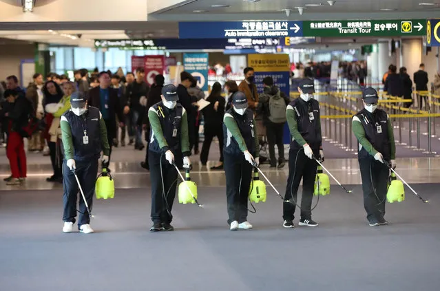 Quarantine workers spray disinfectant at Incheon International Airport, in Incheon, South Korea, 21 January 2020, to prevent the advance of a new strain of coronavirus now spreading in China and other parts of Asia. The National Quarantine Station at the airport stepped up inspections after a Chinese woman, who arrived by plane from the Chinese city of Wuhan on 19 January, tested positive for the new type of pneumonia-like disease. (Photo by Yonhap/EPA/EFE)